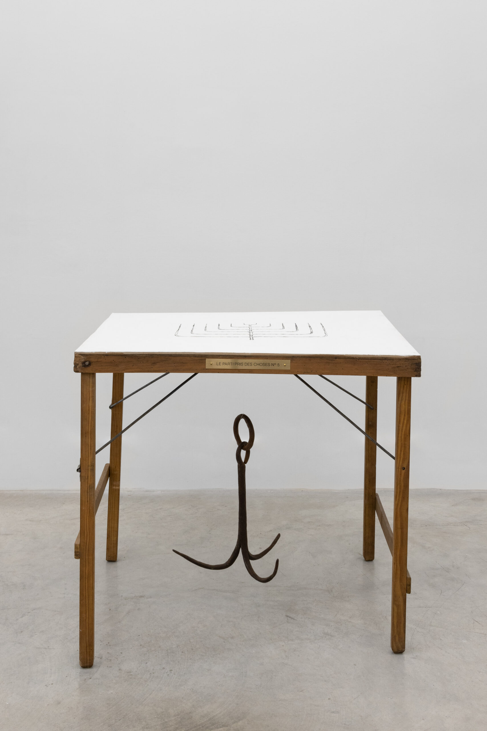 Le parti pris des choses N°5. 2025 Drypoint on chemical carbon paper on wooden surface, acrylic plaster and iron slat Variable dimensions (table: 64.5 x 69.5 x 50 cm; iron slat: 36 x 26 cm)